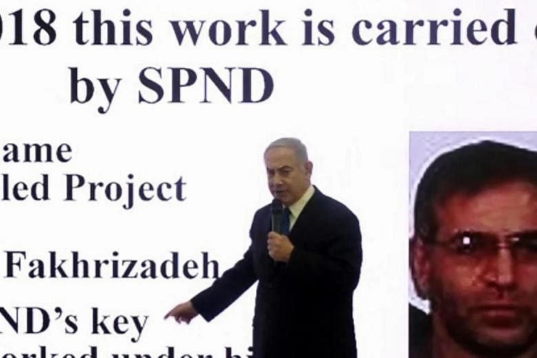 A screen grab from an AFPTV video in April 2018 showing Israeli Prime Minister Benjamin Netanyahu making a speech on Iran's nuclear programme with a slide behind him of Iranian scientist Mohsen Fakhrizadeh.