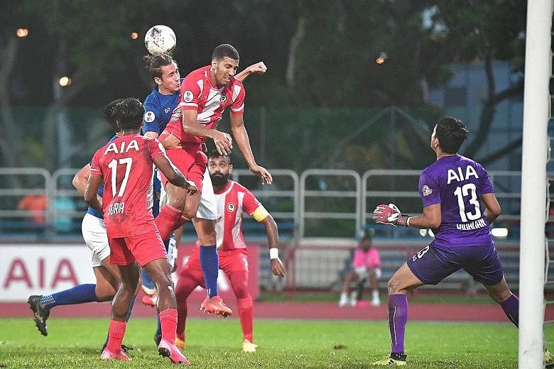 Hougang defender Anders Aplin (in blue) heading the ball away against Tanjong Pagar in yesterday's game. He scored their second goal in the 3-2 win over the Jaguars at Hougang Stadium. ST PHOTO: DESMOND WEE