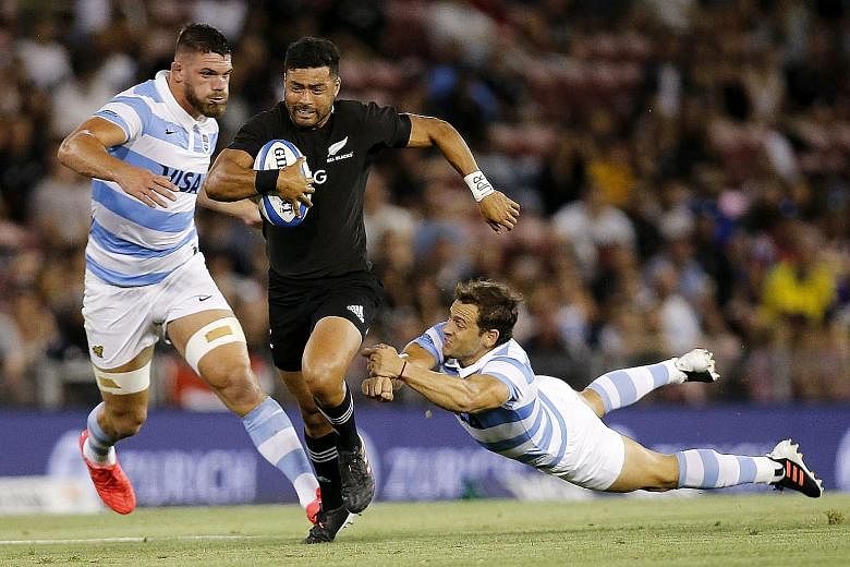 Above: New Zealand's Richie Mo'unga evading the tackle of Argentina's Nicolas Sanchez during their Tri Nations match at McDonald Jones Stadium yesterday. Right: Skipper Sam Cane laying an All Blacks No. 10 jersey emblazoned with Diego Maradona's name