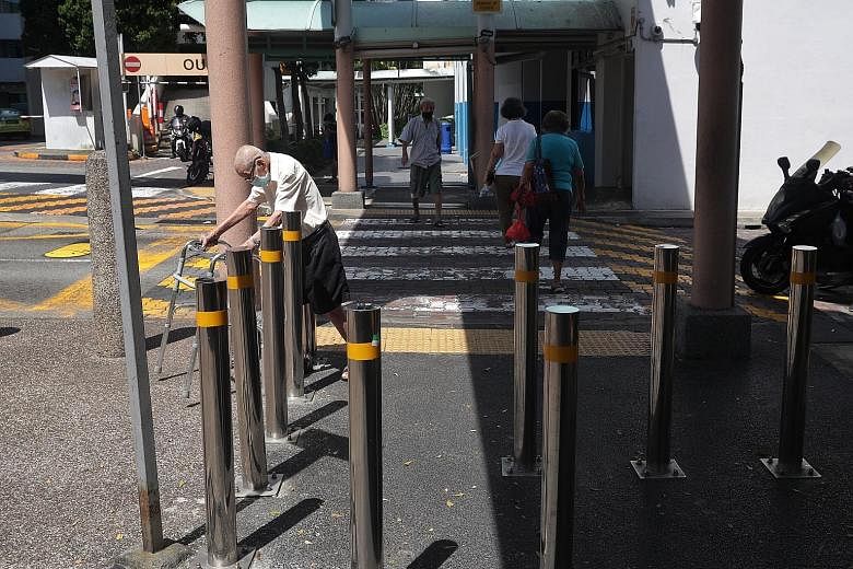 An elderly man with a walking aid navigating past a set of bollards near a pedestrian crossing between 3 Jalan Bukit Merah and the ABC Brickworks Market. Such barriers - placed along walkways to deter reckless motorcyclists, cyclists and motorised pe