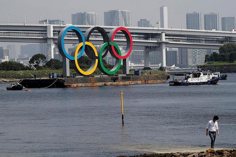 Boats towing the giant Olympic rings, which were removed for maintenance, at the waterfront area in Odaiba Marine Park in Tokyo in August. The shift to next year has caused logistical headaches, but is far less painful than cancelling it, with sponso