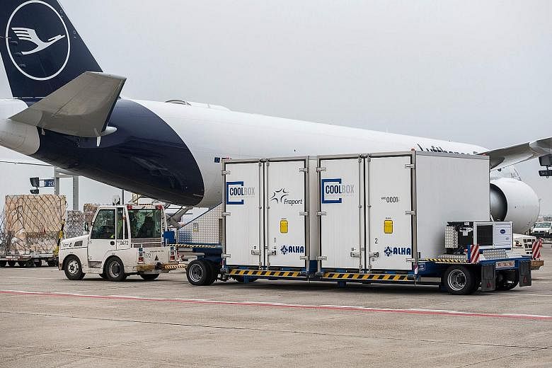 Special cooling containers in front of a Lufthansa cargo plane at Frankfurt Airport. As various Covid-19 vaccines near approval, all eyes are now turned to the mammoth logistical challenge of distributing billions of doses to innoculate the world's p
