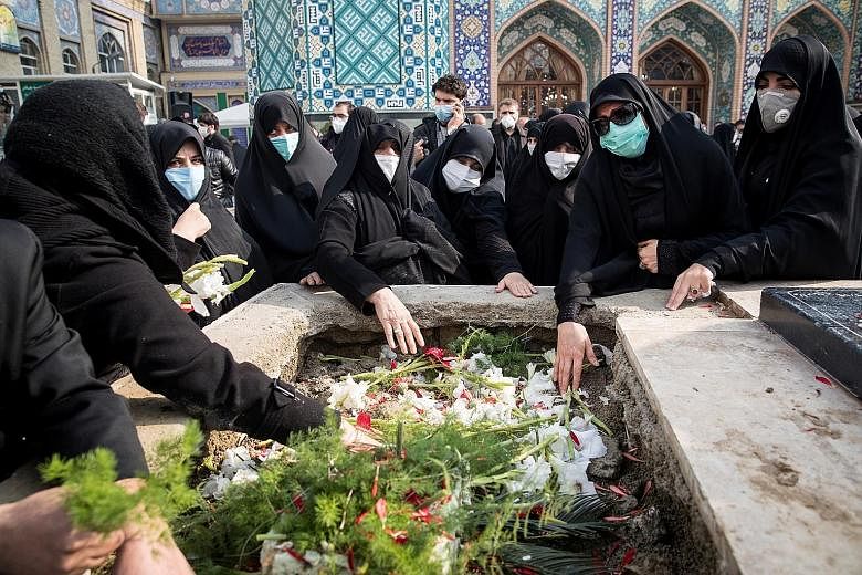 Mourners at the burial ceremony for Iranian nuclear scientist Mohsen Fakhrizadeh at the Imamzadeh Saleh cemetery in northern Teheran yesterday. The veteran physicist, who played a major role in the country's nuclear research and defence activities, w
