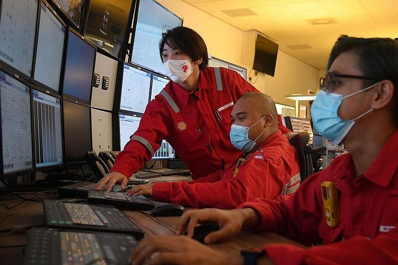 Team leader Lee Xue Ling (standing) with technicians at a control room in Shell's Pulau Bukom refinery yesterday. Ms Lee is one of the potential beneficiaries of the Joint Capability Council, which, in the first phase, will offer training programmes 