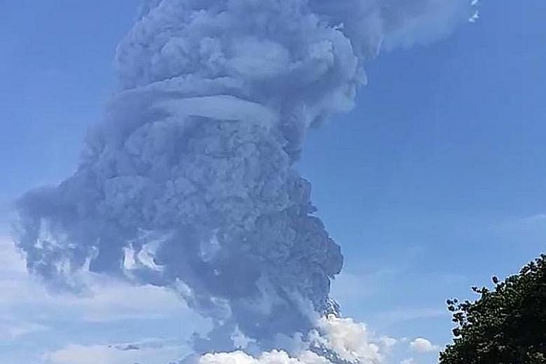 Residents gathering to watch as Mount Ili Lewotolok erupted on Sunday, sending a thick tower of debris 4km into the sky, in Indonesia's East Nusa Tenggara province. PHOTO: AGENCE FRANCE-PRESSE