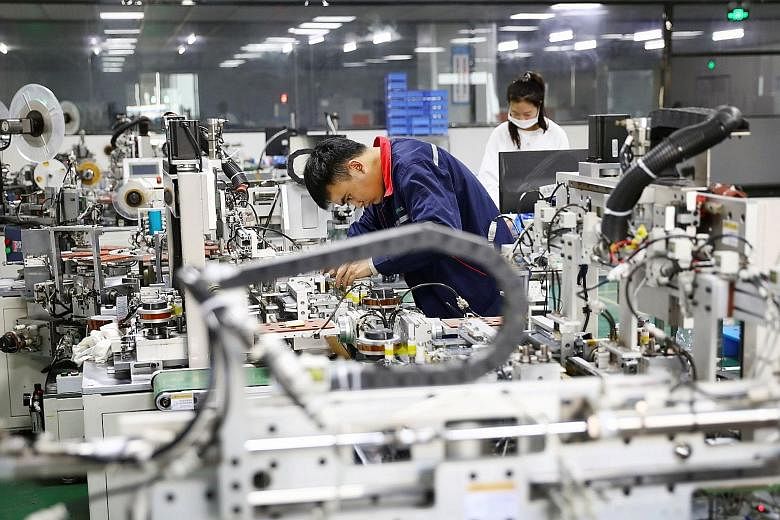 Employees in the workshop of a lithium battery manufacturing company in eastern China's Anhui province. The Caixin/Markit Manufacturing Purchasing Managers' Index rose to 54.9 last month from October's 53.6, the highest reading since November 2010. P