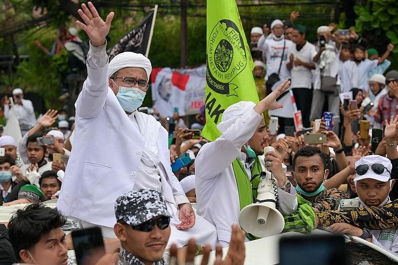 Cleric Rizieq Shihab waving to supporters on Nov 10 after his return to Indonesia. He has cancelled plans for future gatherings. PHOTO: AGENCE FRANCE-PRESSE