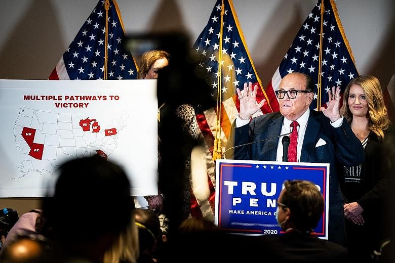 US President Donald Trump's personal lawyer Rudy Giuliani addressing a news conference in Washington about the election results last month. Mr Giuliani was under investigation as recently as this summer by federal prosecutors in Manhattan for his bus