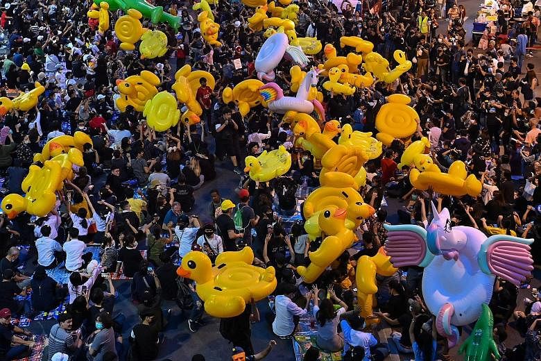 Thai pro-democracy protesters carrying large inflatable ducks during an anti-government rally at Lat Phrao intersection in Bangkok yesterday. They alleged that Prime Minister Prayut Chan-o-cha got preferential treatment and repeated their months-long