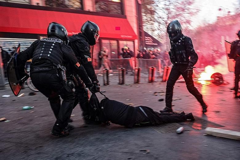 Police officers dragging a man on the ground during a protest in Paris last Saturday against a draft security law that would ban people from sharing images of police officers for "malicious purposes".