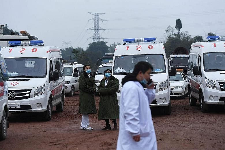 Rescue personnel waiting yesterday beside ambulances, outside the Diaoshuidong coal mine in Chongqing city. Rescuers working on an emergency generator at the Chongqing mine as part of efforts to reach five workers trapped after Friday's accident. PHO
