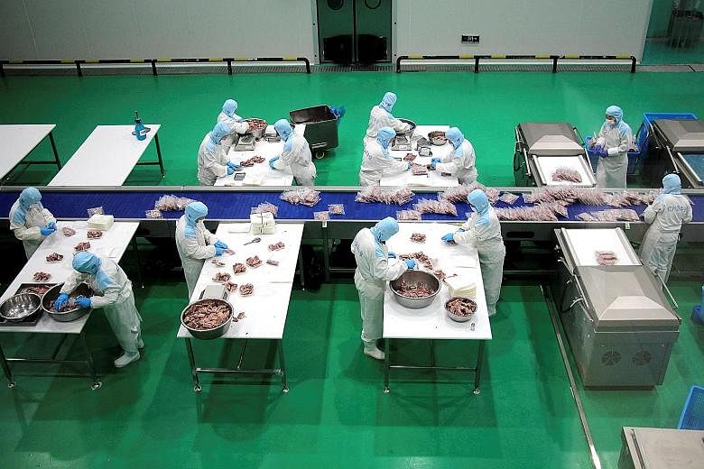 Workers packaging frozen steak for export at a beef processing plant in Shandong province on Sunday. Chinese firms shipped US$268 billion (S$359 billion) in goods in November, the most for any single month and more than 21 per cent higher than the sa