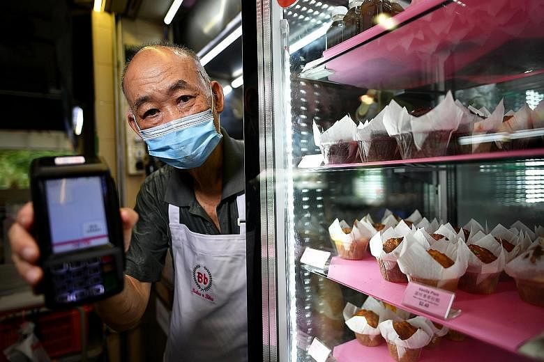 Mr Christopher Lau, owner of Bakes n Bites, with a Nets terminal at his stall in Old Airport Road Food Centre. A recent visit showed that 80 per cent of all the hawkers there use a payment QR code or a Nets terminal. Mr Don Eng, owner of Pasta Manna,
