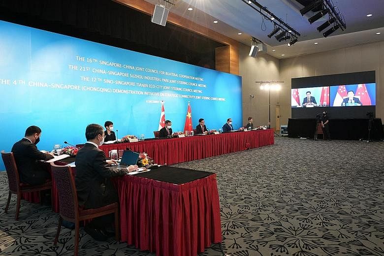 Deputy Prime Minister Heng Swee Keat co-chairing the meetings yesterday with Chinese Vice-Premier Han Zheng (on screen). With Mr Heng are (facing the camera, from left) Minister for Sustainability and the Environment Grace Fu, Health Minister Gan Kim