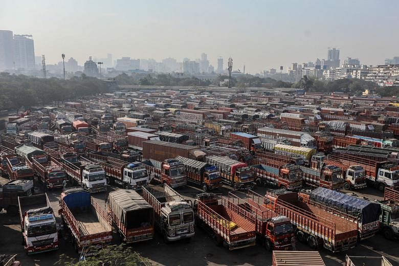 IN NAVI MUMBAI Above: Heavy goods vehicles sitting in a truck terminal during a nationwide strike called by farmers yesterday. IN BANGALORE Left: Activists holding up agriculture produce during a demonstration in support of farmers yesterday. IN ALLA