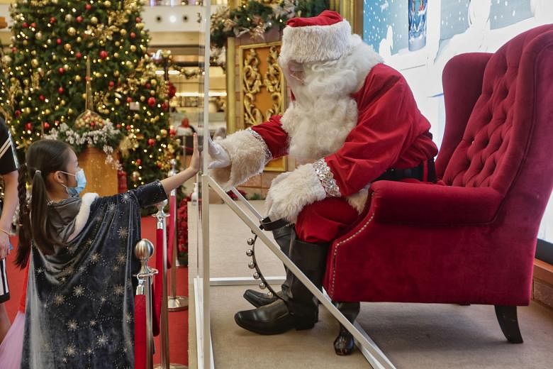 Even Santa Claus has to wear a face shield when interacting with children at a mall in Kuala Lumpur. Malaysia is expected to receive its first batch of Covid-19 vaccines to immunise 6.4 million people as early as next month. PHOTO: EPA-EFE