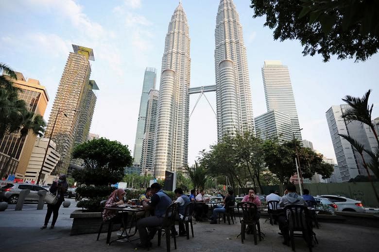 Open-air dining in front of Petronas Twin Towers in Kuala Lumpur last month. Malaysia's Finance Minister Tengku Zafrul Aziz said "the government is disappointed with Fitch's rating outcome, particularly during these exceptional times as the Covid-19 