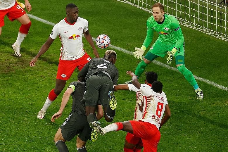 Man United substitute Paul Pogba (No. 6) leaping the highest to head the ball towards goal, forcing an own goal off Leipzig's Ibrahima Konate. Nevertheless, it was too little too late, as the English side crashed out of the Champions League after the