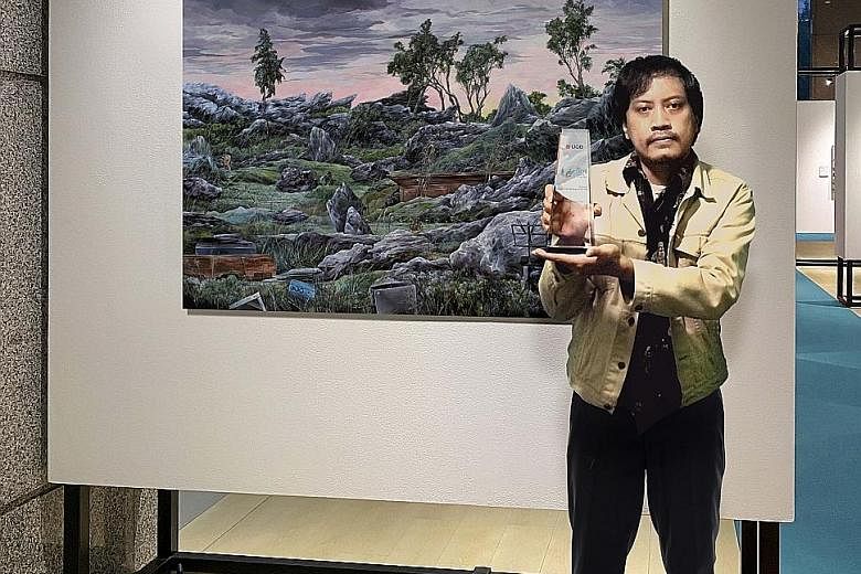 Indonesian artist Prabu Perdana with the UOB Painting of the Year (Indonesia) award for his work titled Isolated Garden, which depicts his studio as a garden littered with personal belongings. He has also won the UOB South-east Asian Painting of the 