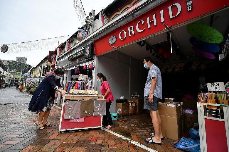 Ms Cindy Zhao (left), owner of souvenir shop Orchid in Pagoda Street, moving her goods in August after shutting some shops owing to lack of business amid the coronavirus outbreak. From Jan 15 next year, small and micro businesses hit by the fallout f