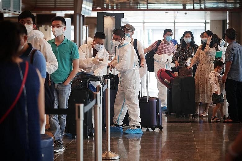 Travellers waiting to check in for a flight at Changi Airport in October. Some Singaporeans are keen to get a Covid-19 vaccination as soon as possible so they can resume travelling.
