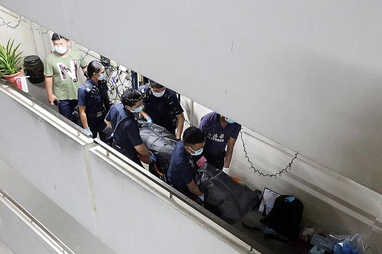The bodies being removed from the flat in Ho Ching Road on Thursday. Police were alerted to the unnatural deaths at about 4.15pm that day.