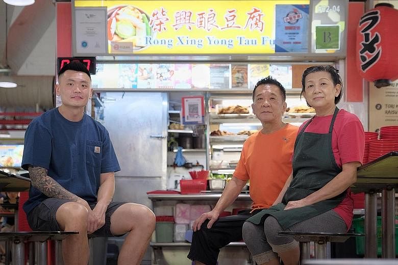 Above: Mr Clement Wang learning the trade from Madam Tee Chun Moy at her Rong Xing Yong Tau Fu stall in Tanjong Pagar. Left: Madam Tee, with her husband Foo Soo Lim who also works in the stall, and Mr Wang. She has imparted her skills from 36 years i