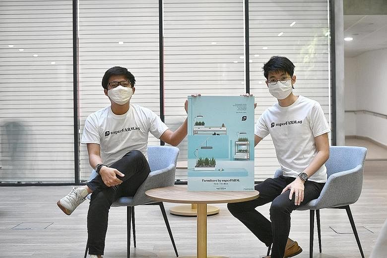 SuperFARM principal investigator Toby Fong (far left), 26, and co-investigator Ong Jun Ren, 25, with a poster of their project on a less bulky and more cost-efficient home hydroponics system. ST PHOTOS: ARIFFIN JAMAR (From left) NUS graduates Ryan An