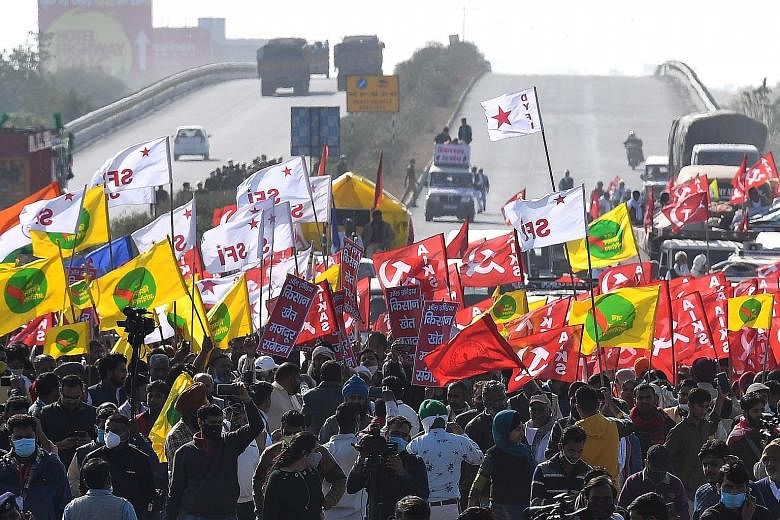 Indian farmers and union leaders marching along a highway on the Haryana-Rajasthan border yesterday to demonstrate against the central government's recent agricultural reforms. PHOTO: AGENCE FRANCE-PRESSE