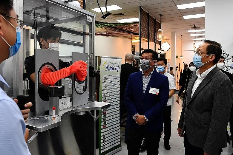 Second Minister for Trade and Industry Tan See Leng (right) with Mr Marcus Sia, managing director of surface finishing firm ATC, at A*Star's pilot Innovation Factory @ SIMTech yesterday. ATC is among 14 firms that have joined the innovation factory t