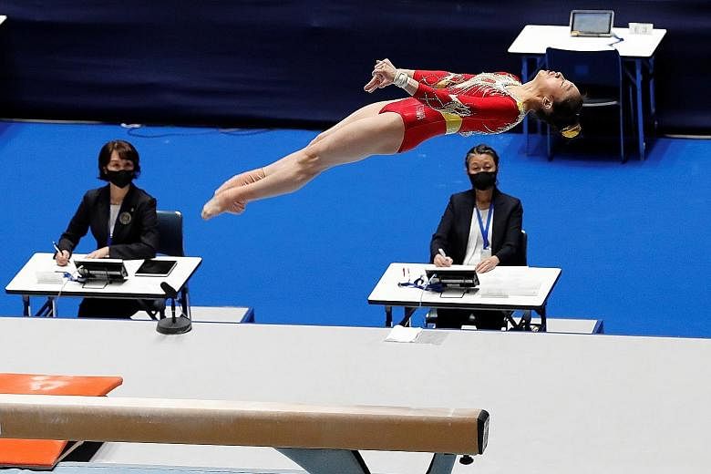 Judges scoring China gymnast Zhou Ruiyu's performance on the balance beam at a recent competition in Tokyo, one of several events held to test Tokyo Olympics' coronavirus protocols.