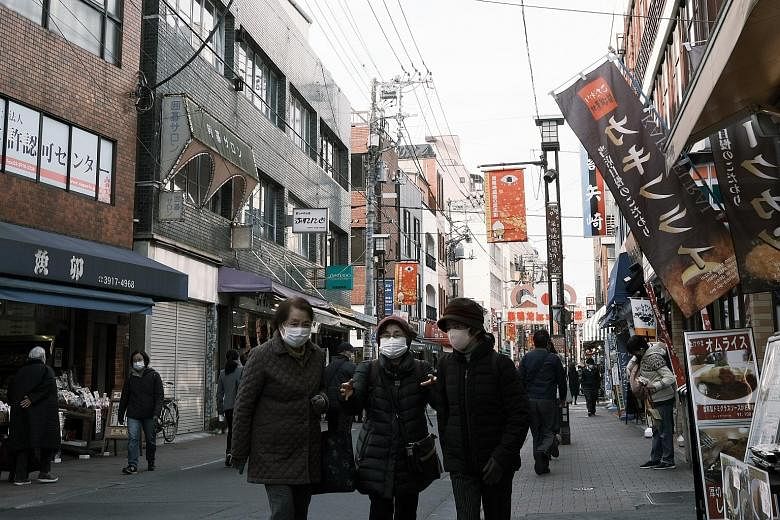 Pedestrians in a shopping street in Tokyo's Toshima ward last week. Japan's consumer prices remain subdued due to weak domestic demand and the government's discount travel campaign to support the tourism industry. PHOTO: BLOOMBERG