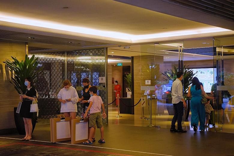 Guests at the Mandarin Orchard Singapore's pick-up point (above) yesterday. Staycations at the hotel (left) in Orchard Road were cut short after the Ministry of Health said it was probing 13 Covid-19 cases among people who had served their stay-home 