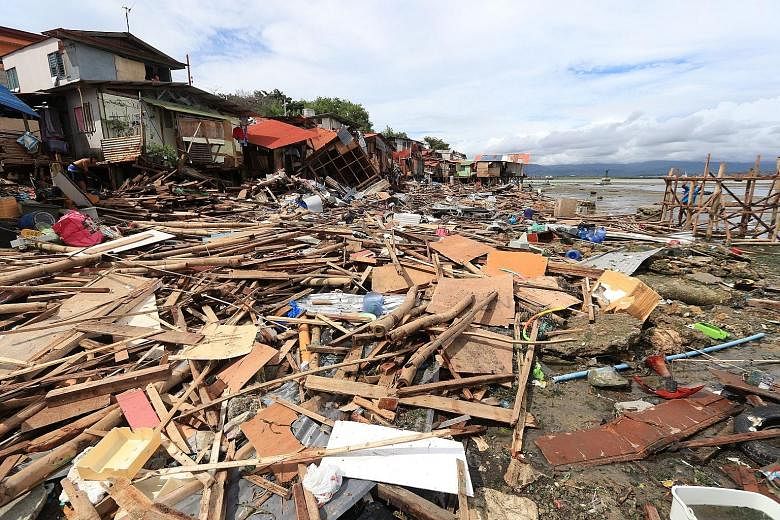 Piles of wood were all that remained yesterday of some houses on Lapu-Lapu island in Cebu province after a storm caused floods, landslides and huge waves in the Philippines on Friday. PHOTO: AGENCE FRANCE-PRESSE