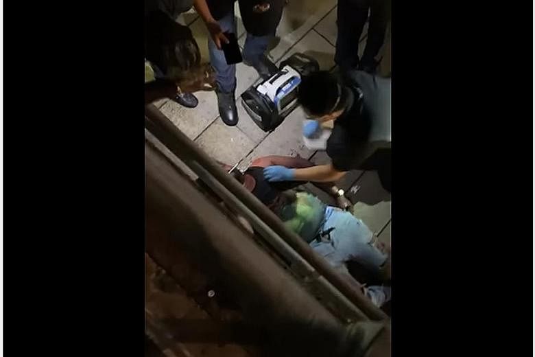 A screengrab of a video of the fight, which shows paramedics tending to a man lying on a walkway leading towards an underpass outside The Central mall in Clarke Quay on Saturday night.