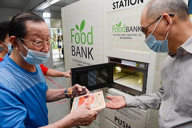 Above: Mr Jacky Tham (left) redeemed coffee and cooked food from an automated food bank vending machine yesterday. Top: The vending machines are part of a new initiative to help those who live in rental blocks or one-to two-room studio apartments aro