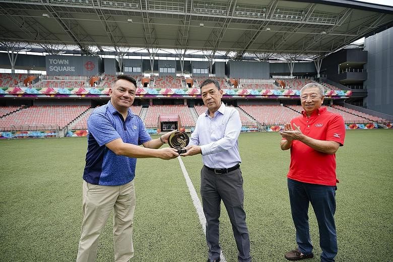 Senior director at Our Tampines Hub (OTH) Suhaimi Rafdi (far left) receiving the 2019 International Olympic Committee (IOC) Trophy "Sport and Sustainable Architecture" from Singapore National Olympic Council (SNOC) secretary-general Chris Chan at OTH