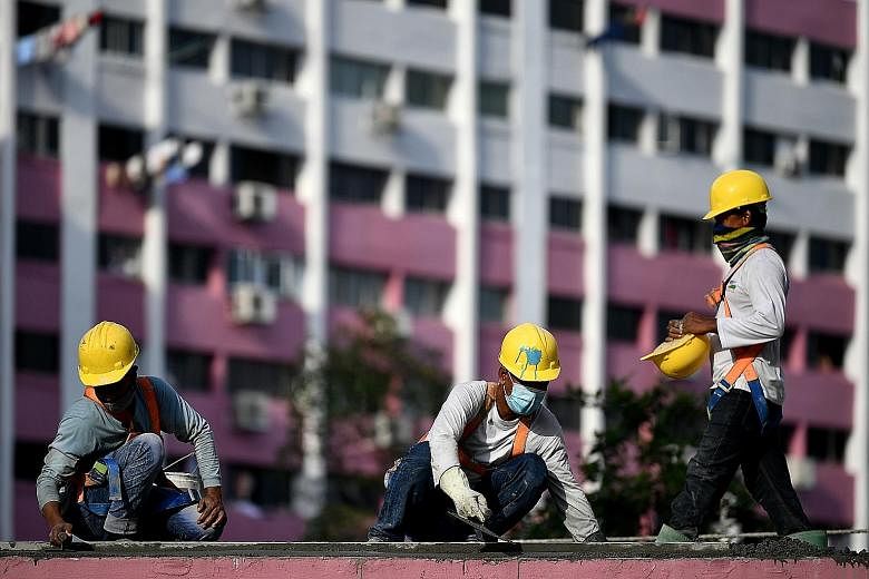 Construction workers at work on the roof of a walkway last month. Singapore has about 1.3 million foreign workers, of whom some 300,000 work in the construction industry. About 10 per cent to 15 per cent of workers in the sector had returned home ami