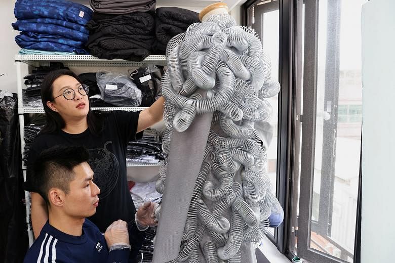 Ms Wang inspecting a dress at her studio in Taipei earlier this month. The designer stitches wires and other materials to dresses, giving them a futuristic feeling. Taiwanese designer Wang Li-ling (far left) thanking guests for coming to her fashion 