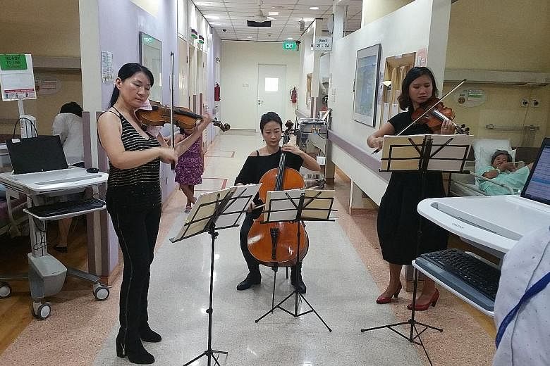 Sing'theatre musicians performing for patients at National University Hospital in 2015. In the light of the pandemic, they have now taken their performances online, including weekly virtual shows at Singapore General Hospital for an average of 15 to 