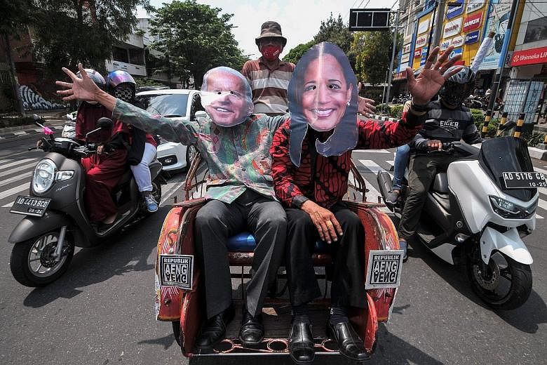Indonesians in Java wearing masks of Mr Joe Biden and Ms Kamala Harris after the Democrats won the US presidential election. The writers say South-east Asian countries will welcome the reversion to traditional US foreign policy settings and behaviour