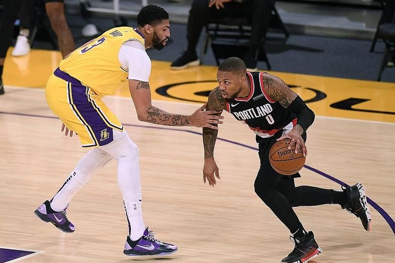 Portland guard Damian Lillard, facing Lakers' Anthony Davis, scored 31 points in the win over the NBA champions on Monday.