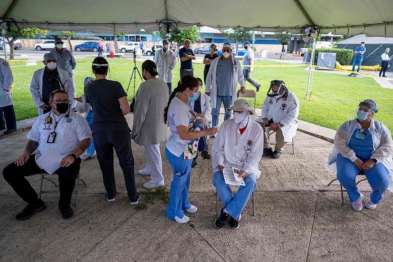 Medical workers at Puerto Rico Medical Centre in San Juan, Puerto Rico, waiting to receive the Pfizer-BioNTech vaccine earlier this month. Covid-19 vaccines like the ones from Moderna and Pfizer-BioNTech (both bottom) are expected to accelerate the e