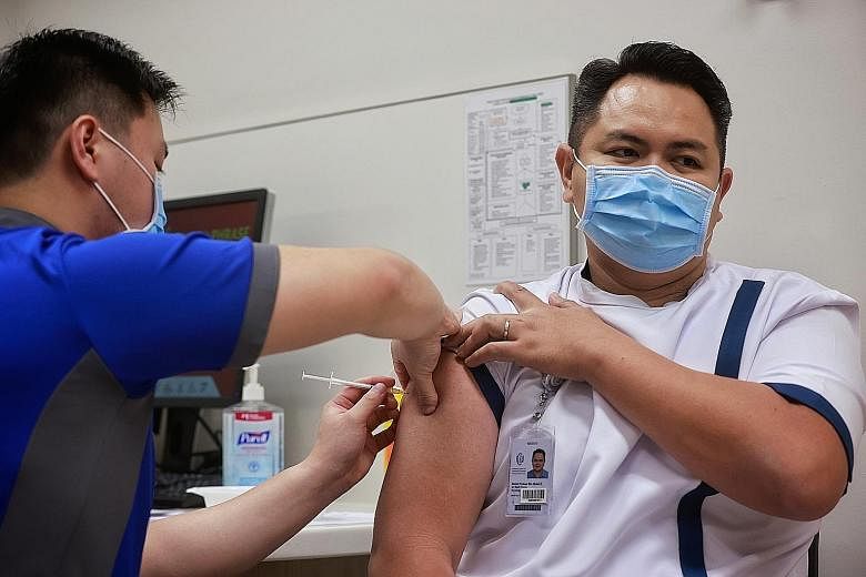 NCID senior staff nurse Mohamed Firdaus Mohamed Salleh getting his Covid-19 vaccination jab yesterday. He works in the intensive care unit looking after Covid-19 patients.
