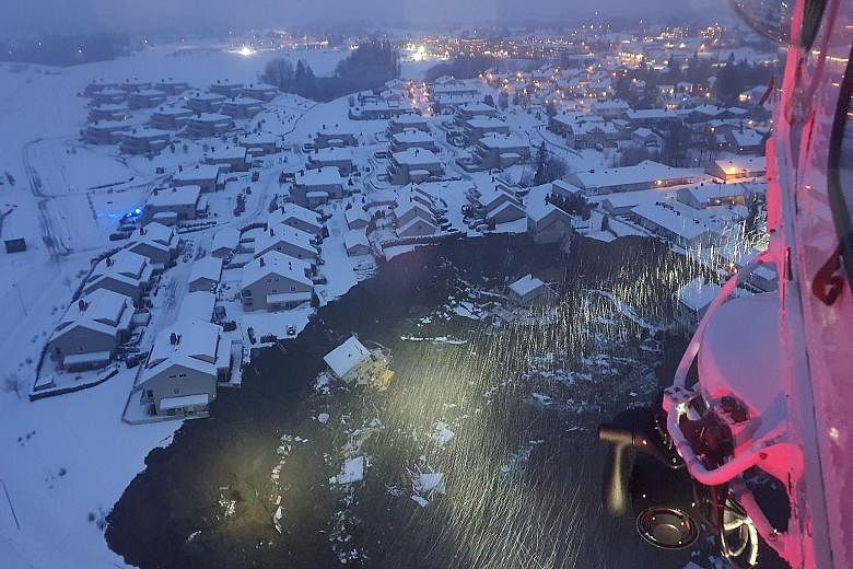 A helicopter view of the site of the landslide, showing a large crater with destroyed buildings at the bottom of it, in the municipality of Gjerdrum, Norway, yesterday. About 700 people have been evacuated from the area. PHOTO: REUTERS