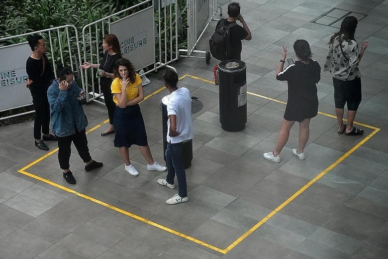 Smokers in a designated smoking zone in Orchard Road. It may be time to consider extending the Orchard Road smoke-free zoning to even more places, including the Central Business District and the heartland neighbourhoods, say the writers. If the desig