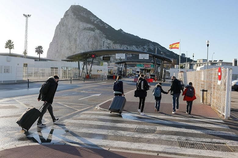 A British family crossing the border from Spain to the British Overseas Territory of Gibraltar in the Spanish city of La Linea de la Concepcion yesterday. Without the agreement reached to keep the land border open, tens of thousands of Spaniards and 