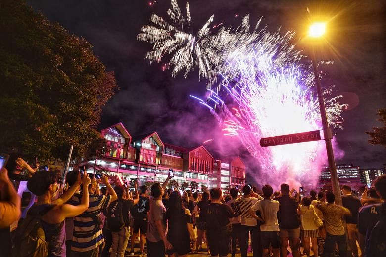 Members of the public at an open field yesterday behind Wisma Geylang Serai, one of 11 heartland locations that ushered in the new year with a fireworks display. Community countdown programmes also went virtual for the first time, with some including