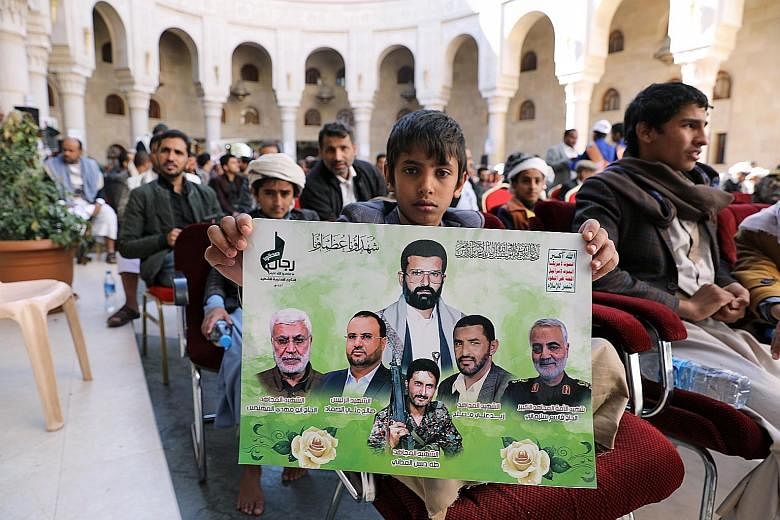 Left: Members of the Lebanese Shi'ite Hizbollah taking part in a parade yesterday under a large poster of slain Iraqi commander Abu Mahdi al-Muhandis (left) and Iran's Maj-Gen Qasem Soleimani. PHOTO: AGENCE FRANCE-PRESSE