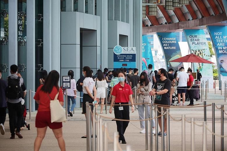 Visitors queueing outside S.E.A. Aquarium on Sentosa last month. Various places have introduced time slots to prevent overcrowding, and during the school holidays, many reportedly could not use their tickets for fully booked attractions. The Singapor